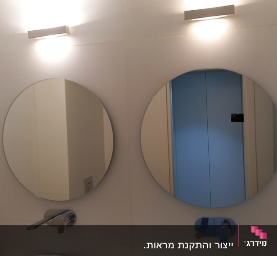 שתי מראות עגולות תלויות על קיר לבן